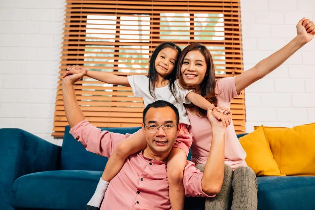 Parents and child smiling joyfully indoors
