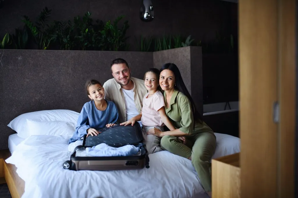 Family packing suitcase on bed